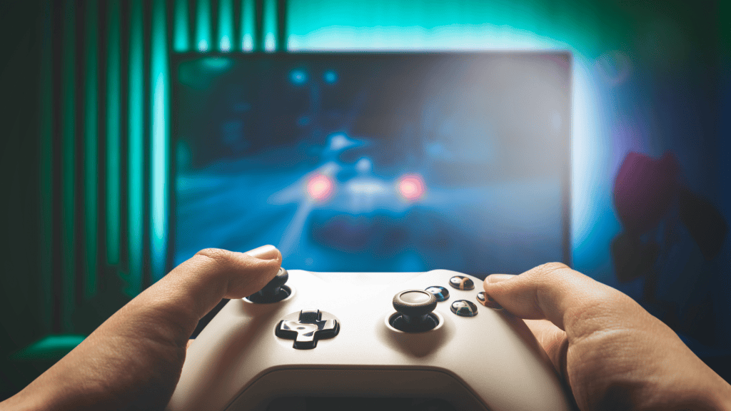 Imagen de una persona agarrando un contro de videojuegos jugando en una pantalla